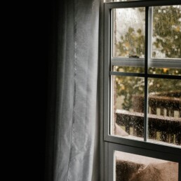 A rain covered window in an early spring day.