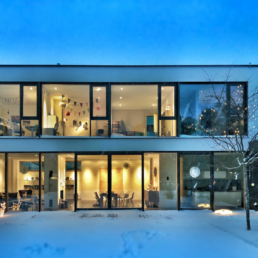 modern home with floor to ceiling windows on every floor creating a wall of windows