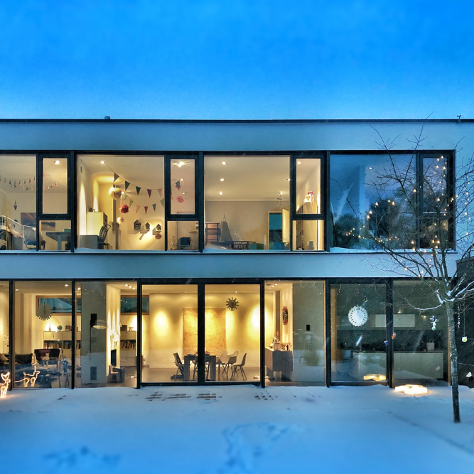 modern home with floor to ceiling windows on every floor creating a wall of windows